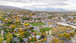 Aerial view of property and surrounding area featuring a mountainous background and nearby suburban area
