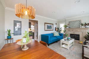 Living room featuring ornamental molding, healthy amount of natural light, a fireplace, arched walkways, and recessed lighting