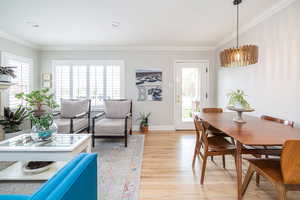 Dining space featuring light wood finished floors, crown molding, and recessed lighting