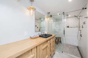 Bathroom featuring vanity, a shower stall, light tile patterned floors, and a textured ceiling