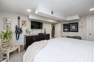 Carpeted bedroom with recessed lighting
