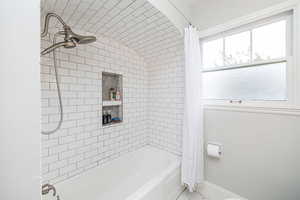 Bathroom featuring shower / bath combination with curtain and tile patterned flooring