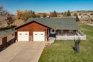 View of front of house featuring stone siding, driveway, a shingled roof, and an attached garage