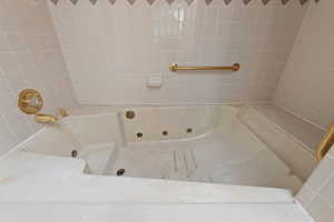 Full bath featuring a combined bath / shower with jetted tub