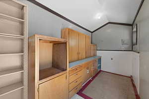 Walk in closet featuring lofted ceiling and light carpet