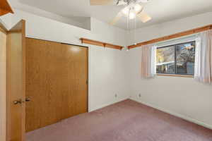 Unfurnished bedroom featuring a closet, carpet floors, and ceiling fan