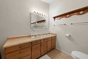 Full bath featuring double vanity and light tile patterned floors