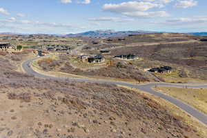 Aerial view of property and surrounding area featuring a mountainous background
