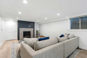 Living area featuring light wood-type flooring, recessed lighting, and a fireplace