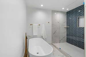 Full bath featuring a soaking tub, recessed lighting, a marble finish shower, and marble finish floors
