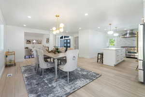Dining space featuring recessed lighting, light wood-style floors, and a chandelier