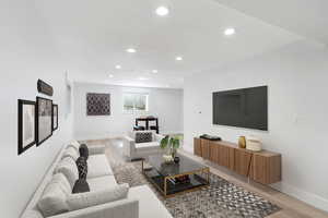Living area with light wood-style flooring and recessed lighting