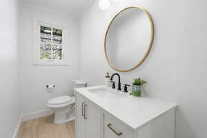 Bathroom with vanity, crown molding, and light wood-style floors