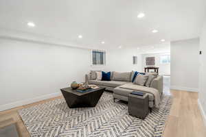 Living area with recessed lighting and light wood finished floors