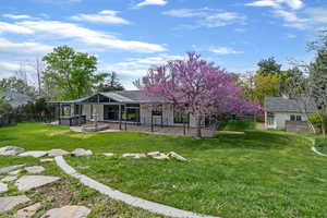 Rear view of house featuring a fenced backyard and a wooden deck