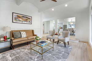 Living area with wood finished floors, ceiling fan, recessed lighting, a wainscoted wall, and a decorative wall