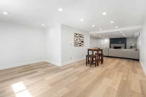 Dining space featuring recessed lighting, a fireplace, and light wood-style flooring