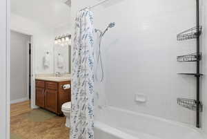 Bathroom featuring shower / bath combination with curtain, vanity, and light tile patterned floors