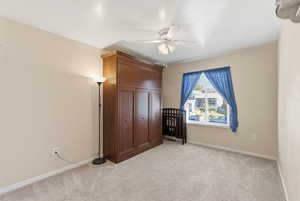 Unfurnished bedroom with light carpet and ceiling fan