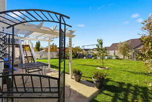 Fenced backyard with a pergola, a patio, and a playground