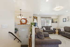 Living area featuring ornamental molding, recessed lighting, and a chandelier
