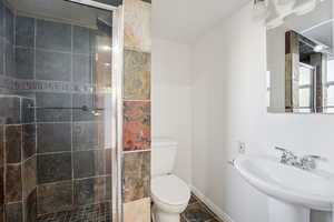 Full bath featuring toilet and a stall shower