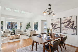 Dining space with wood finished floors and vaulted ceiling