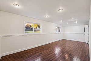 Empty room with dark wood-type flooring