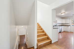 Stairway with wood finished floors and baseboards