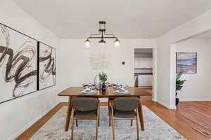 Dining space with light wood-style flooring and a chandelier