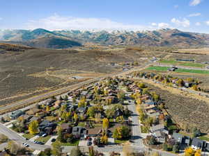 Aerial overview of property's location with a mountain backdrop and nearby suburban area