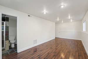 Empty room with dark wood-style floors and baseboards