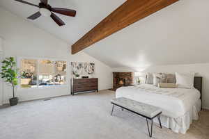 Carpeted bedroom featuring a brick fireplace, beamed ceiling, high vaulted ceiling, and a ceiling fan