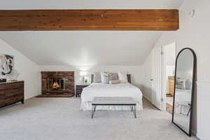 Bedroom featuring light colored carpet and a fireplace