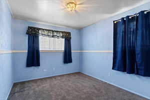 Spare room featuring carpet floors and baseboards
