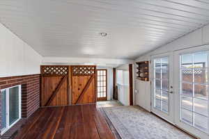 Doorway featuring wood walls, wood-type flooring, and french doors
