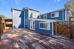 Back of property with a gate, a wooden deck, and french doors