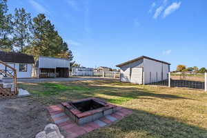 View of yard featuring an outbuilding, an outdoor structure, and an outdoor fire pit