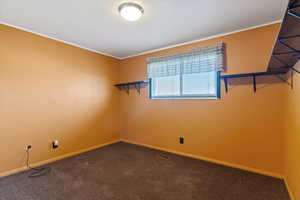 Empty room with dark carpet and ornamental molding