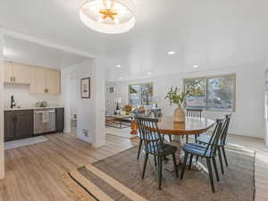 Dining area with light wood finished floors and recessed lighting