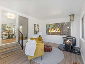 Sitting room with a wood stove and wood finished floors