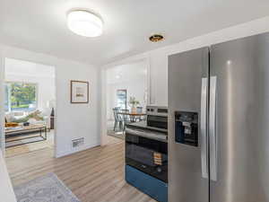 Kitchen featuring stainless steel appliances, plenty of natural light, and light wood-style flooring