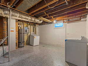 Below grade area with electric panel, secured water heater, and separate washer and dryer