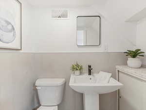 Bathroom with toilet and a wainscoted wall