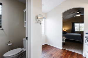 Ensuite bathroom with lofted ceiling, dark wood-style flooring, and a ceiling fan