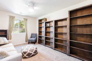 Sitting room with light colored carpet and ceiling fan