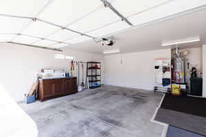 Garage featuring water heater and a garage door opener