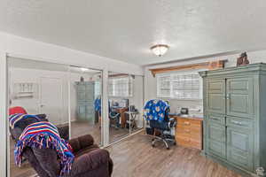 Office area featuring light wood finished floors and a textured ceiling