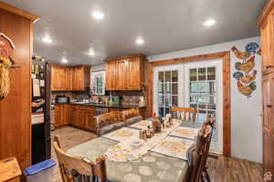 Kitchen featuring brown cabinetry, backsplash, light wood finished floors, a textured ceiling, and recessed lighting