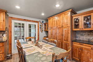 Dining space featuring french doors, wood finished floors, recessed lighting, and a textured ceiling